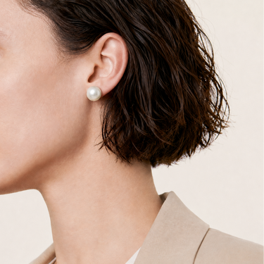 Model wearing 12-13mm white South Sea round pearl stud earrings.