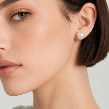 Model wearing 9-10mm white South Sea round pearl stud earrings.