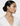 Woman wearing gold earrings and necklace on a white background