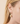 Gold earring with a pearl on a beige background