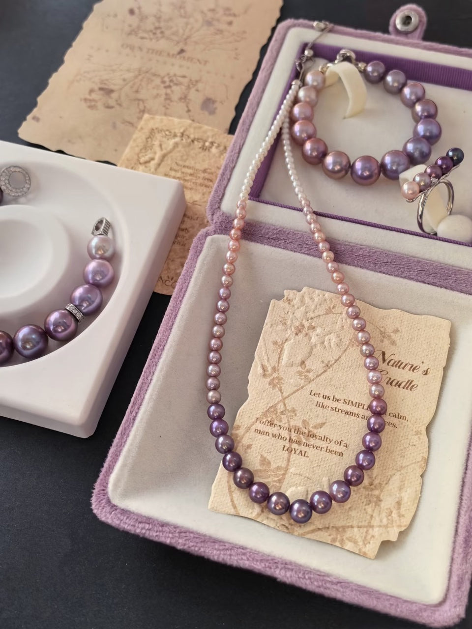 Natural lavender and purple freshwater pearl jewelry displayed in violet boxes